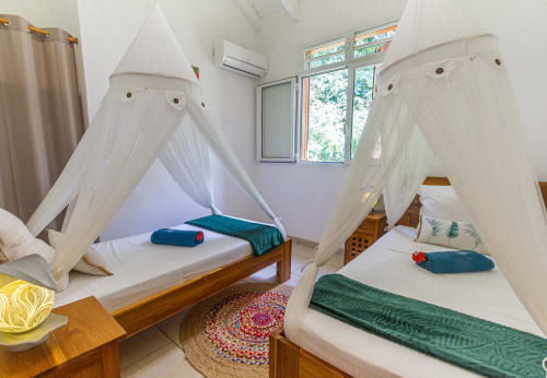 Chambre double climatisée, à l'étage de la villa, avec moustiquaire et placard.