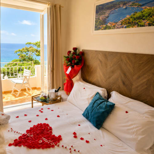 Camera da letto romantica con vista Mare mediterraneo, petali di rosa e bouquet rosso sul balcone di Villa Bina Sea Hotel
