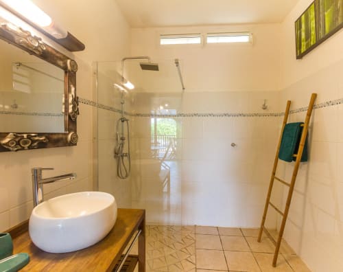 Salle de bains au rez-de-chaussée,  un lavabo rond, une douche et des toilettes.