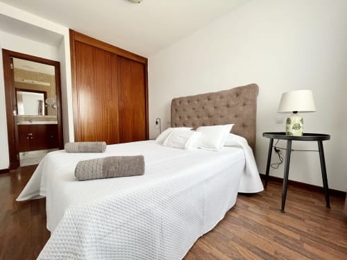 Dormitorio moderno en villa FTV Holidays Homes, La Oliva, con cama de matrimonio, muebles de madera y baño ensuite