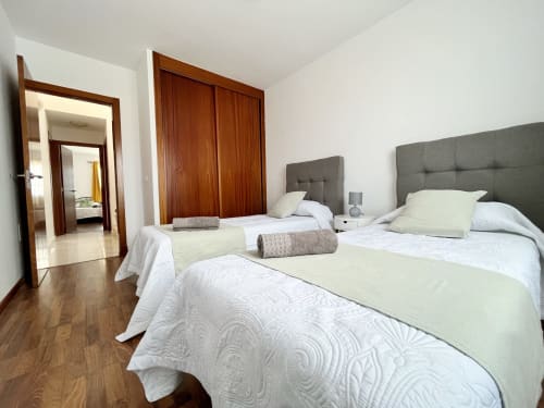 Espacioso dormitorio en villa Casa Laferre, La Oliva, con tres camas, cabeceros gris, armario de madera y suelo de madera