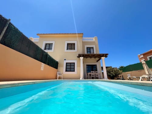 Villa color crema con piscina turquesa en La Oliva, Fuerteventura, España - Casa Laferre alojamiento vacacional