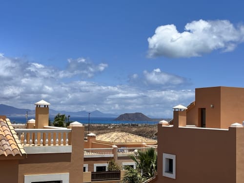 Villa Casa LaFerre en La Oliva con arquitectura de terracota con vistas al paisaje costero y montañas