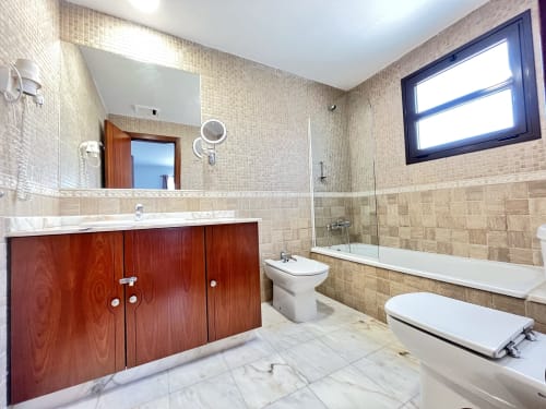 Lujoso baño en villa Casa Laferre de FTV Holidays Homes, La Oliva con mueble de madera, suelos de mármol y bañera