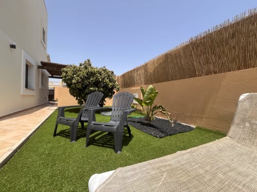 Terraza privada de la villa Casa Laferre en La Oliva con tumbonas, césped artificial y vistas al mar