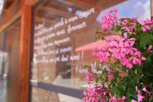 Des fleurs roses éclatantes s'épanouissent à l'entrée de l'auberge Gîte La Péniche à Evolène, Suisse