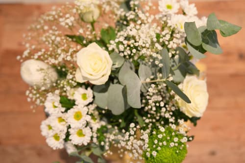 Arrangement floral de roses blanches fraîches et de gypsophile au Gîte La Péniche à Evolène, Suisse