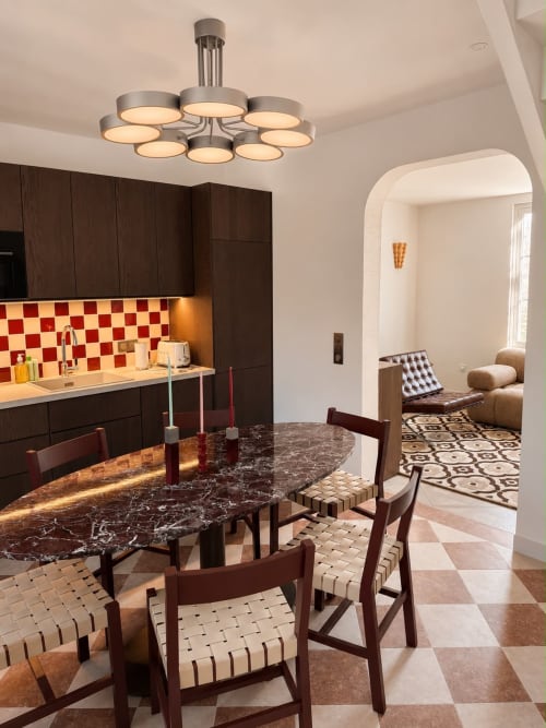 Cuisine-salle à manger moderne de l'hôtel Deauv Hills avec armoires foncées, dosseret à carreaux rouges, table de marbre et