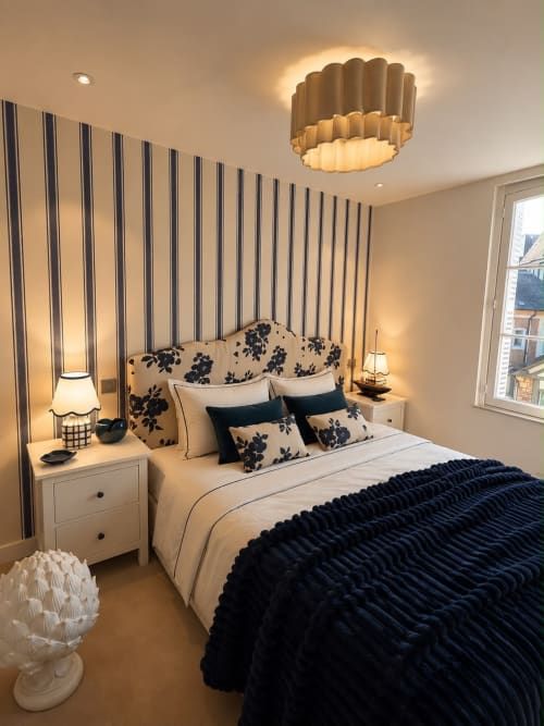 Chambre élégante aux DEAUV HILLS Deauville avec mur à rayures, tête de lit florale et couverture texturée bleu marine