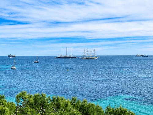 Segelboote und Yachten vor der Küste von Cannes Palm Beach in türkisem Mittelmeergewässer