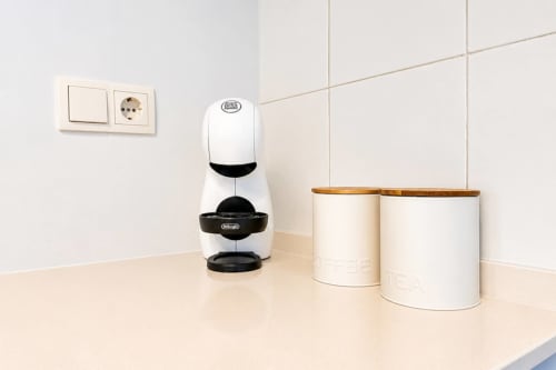 Comptoir de cuisine moderne avec cafetière blanche et bacs de rangement dans un appartement en bord de mer à Valence