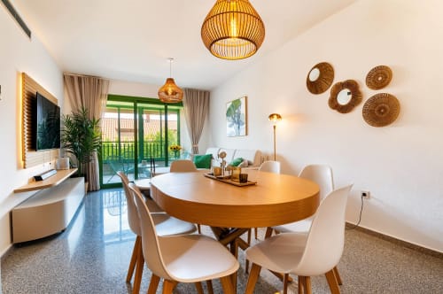 Salle à manger moderne à Valence avec table ronde en bois, suspensions, balcon avec vue mer et décoration contemporaine