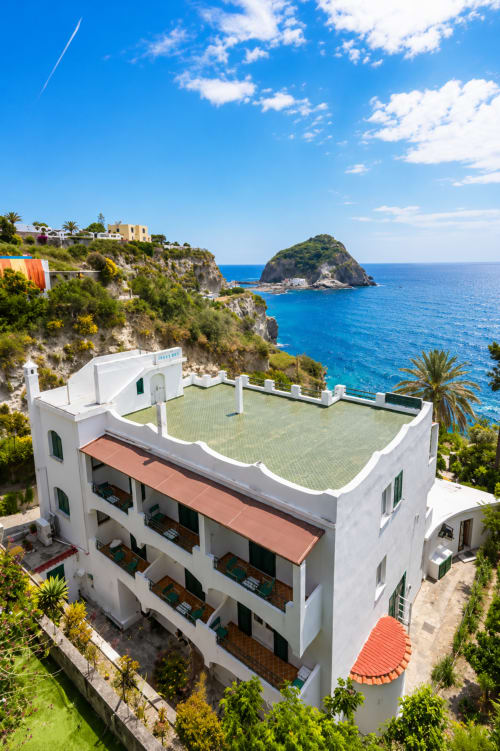 Villa Bina Sea Hotel arroccata sulle scogliere di Ischia con vista sulle acque turchesi del Mediterraneo e all'isolotto vicino