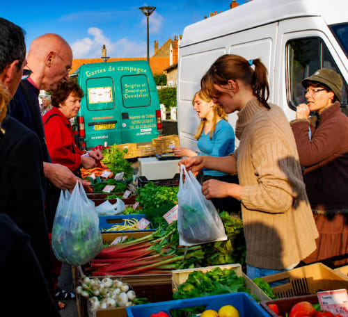 Customers shopping at a farmers market produce stand in Sangatte, France near Ô de Mer hotel