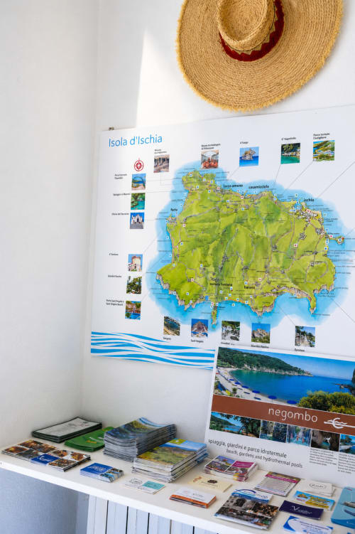 Depliant e mappe di Ischia esposti su uno scaffale presso la Villa Bina Sea Hotel, Serrara Fontana