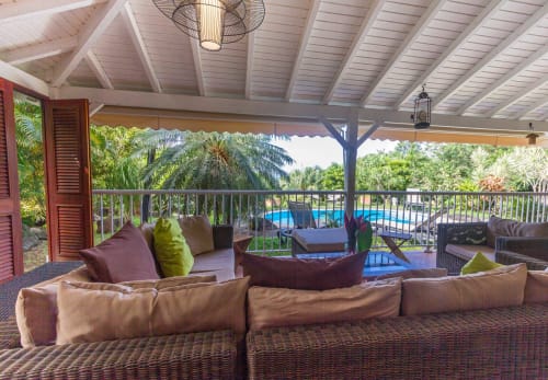 Terrasse de la Villa avec grand salon de jardin avec vue sur la piscine et le jardin tropical. Barrières amovibles sur la terrasse pour sécuriser la piscine. 