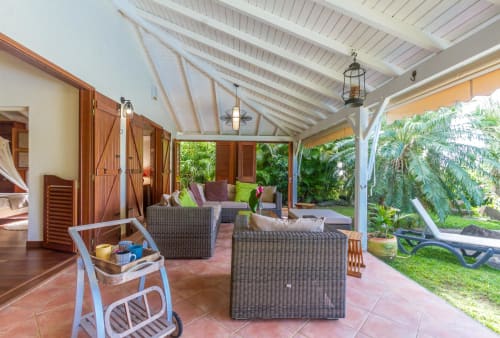 Terrasse de la Villa avec grand salon de jardin avec vue sur la piscine et le jardin tropical. 