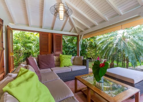 Terrasse de la Villa avec grand salon de jardin avec vue sur la piscine et le jardin tropical.