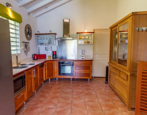 Cuisine équipée avec grand buffet en teck, plaque induction , four électrique, micro-ondes et frigo américain.