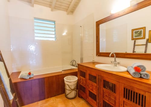 Spacious bathroom with cabinetry, a teak mirror, and a walk-in shower.