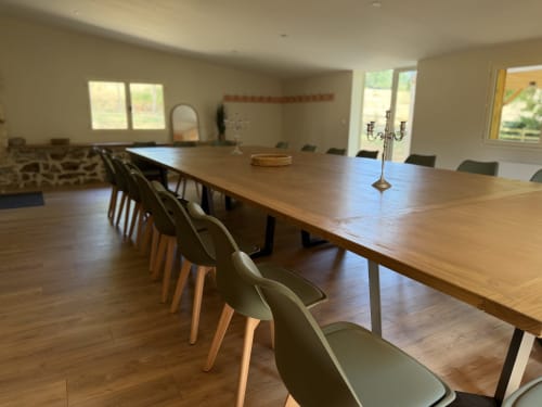 Spacieuse salle de séminaire et de réception au Domaine de Brise Bois avec tables en bois, chaises modernes et vue sur le jardin