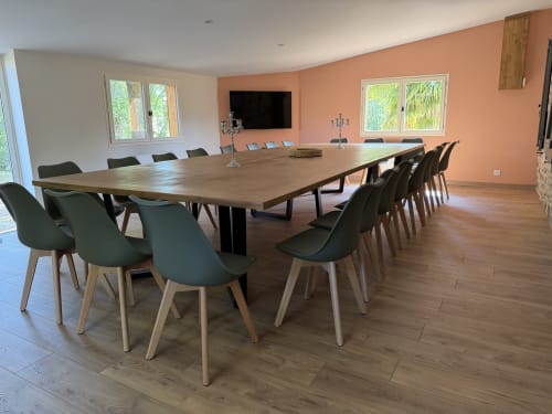 Salle de séminaire privée moderne au Domaine de Brise Bois avec grande table en bois, 16 places et vue sur le jardin