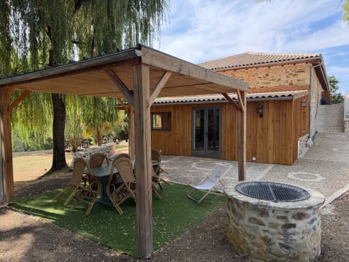 Chaumière en bois avec pergola et foyer à Domaine de Brise Bois, refuge rural français avec jardin et espace repas
