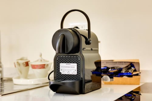 Nespresso coffee machine on desk in Domus Praeclara Merulana luxury hotel room with amenities