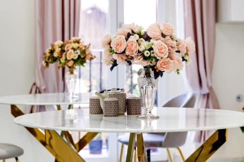 Elegant round white table with peach roses in crystal vase, luxury hotel room décor at Domus Praeclara Merulana