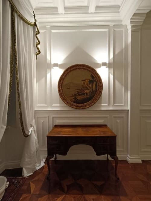 Elegante Magna Mater Suite con dettagli architettonici classici, scrivania in legno e pannello decorativo circolare in rilievo