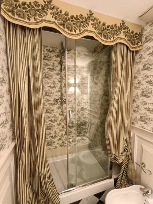 Bagno elegante della Suite Magna Mater con doccia in vetro e tende a righe in appartamento hotel italiano