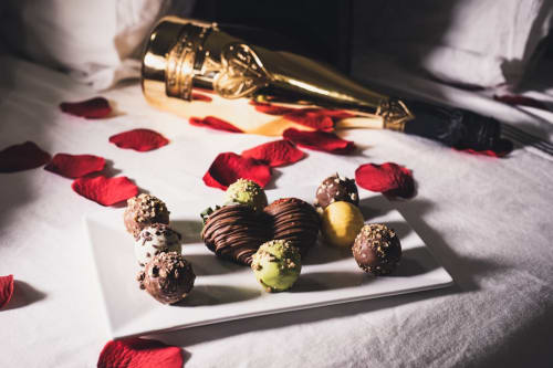 Eleganti cioccolatini gourmet e champagne con petali di rosa presso Roma Imperial Suites, lussuoso bed and breakfast a Roma
