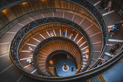 Scala a spirale con ringhiere ornamentali alle Roma Imperial Suites a Roma, vista dall'alto che mostra più piani