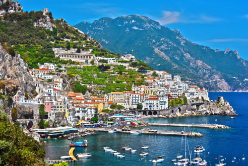 Suggestivo villaggio costiero di Castellammare di Stabia con barche colorate, montagne e il Mar Mediterraneo
