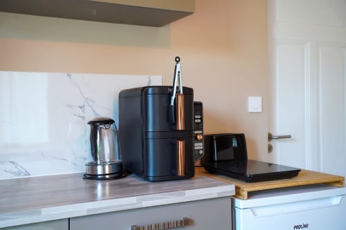 Coin cuisine du Le 1 Péraudel avec bouilloire électrique, cafetière et électroménagers noirs dans le studio de Castres