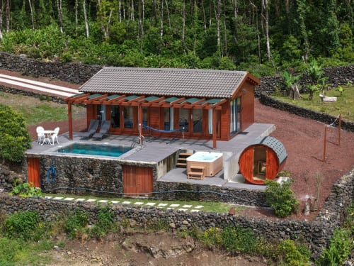 Moderna cabana de madeira com banheira de hidromassagem e sauna no hotel Adega da Quinta em Madalena, Portugal, rodeada por floresta exuberante
