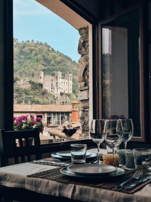 Elegant dining setup overlooking medieval castle in Dolceacqua, Italy from Talking Stones Group B&B