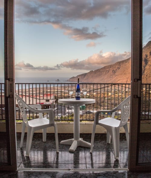 Balcón con sillas y mesa blancas con vistas al mar de Frontera en Apartamentos Jucar