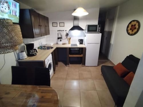 Cuisine ouverte et séjour dans un studio au Sunshine Conciergerie hostel à Fort-de-France avec table à manger