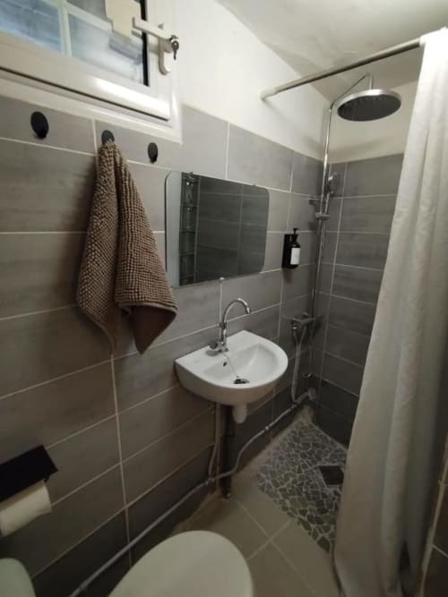 Salle de bains moderne à l'auberge Sunshine Conciergerie à Fort-de-France avec douche, lavabo, miroir et carrelage
