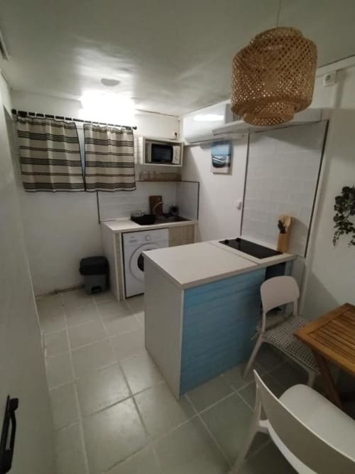 Cuisine compacte et coin repas à l'appartement Sunshine Conciergerie de Fort-de-France avec îlot central bleu
