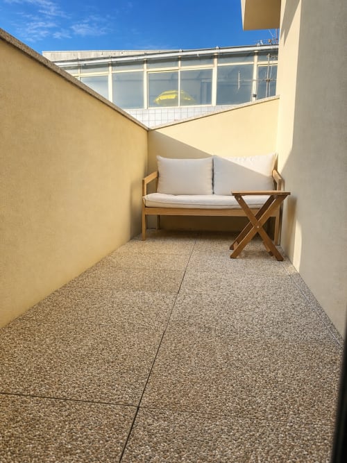 Terraço ensolarado com banco de madeira e almofadas brancas na Terra Clara Studios, Esposende Portugal