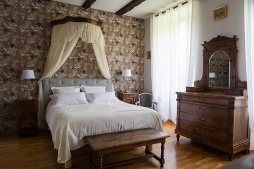 Chambre élégante avec lit à baldaquin, papier peint fleuri ornementé et mobilier en bois ancien à La demeure du Comte, Salles-la-Source