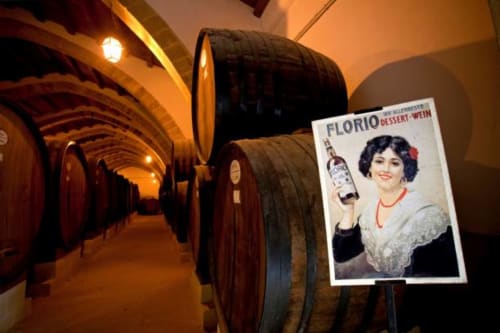 Cantina con botti di legno e manifesto vintage Florio Dessert Wine a Villa Giulia sul Mare, Marausa Lido Sicilia