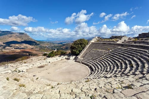 Rovine di antico anfiteatro greco con vista sulla spiaggia di Marausa in Sicilia sotto cielo azzurro