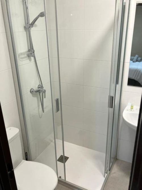 Moderna cabina de ducha con puertas de cristal en Hostal Restaurante El Encuentro en Barraco