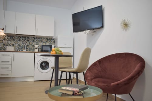 Moderno apartamento estudio en Mérida con sala, cocina americana, TV pantalla plana, sillón burdeos y mesa de comedor
