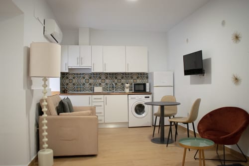Apartamento estudio moderno en Mérida con cocineta, asientos confortables, comedor y TV de pantalla plana