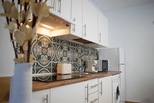Cocina moderna en Apartamento Diocles Centro, Mérida con muebles blancos, encimera de madera y detalles azul y oro