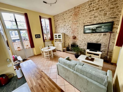 Cottage CM1 living room at La Recreation, Missillac - stone walls, yellow accents, sofa, dining area, fireplace